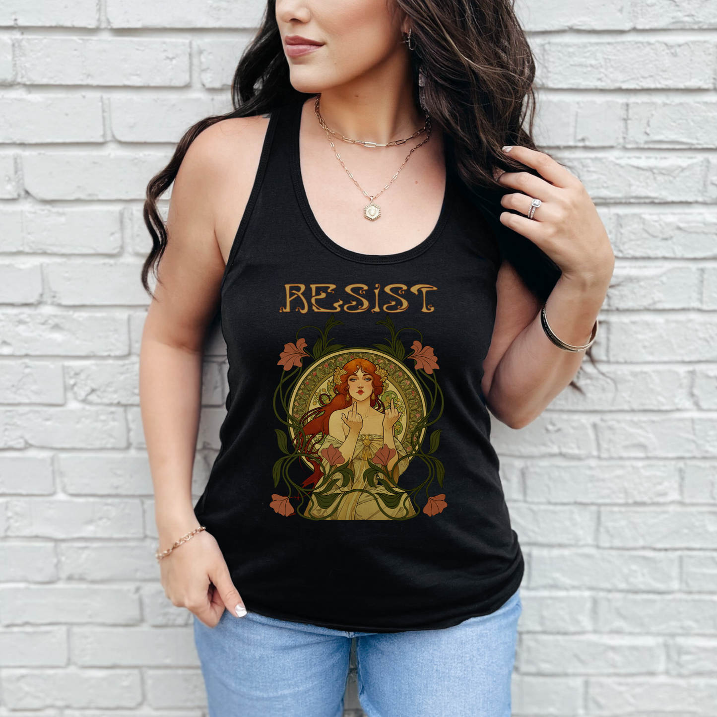 Woman wearing a black tank top with 'RESIST' graphic design against a white brick wall.