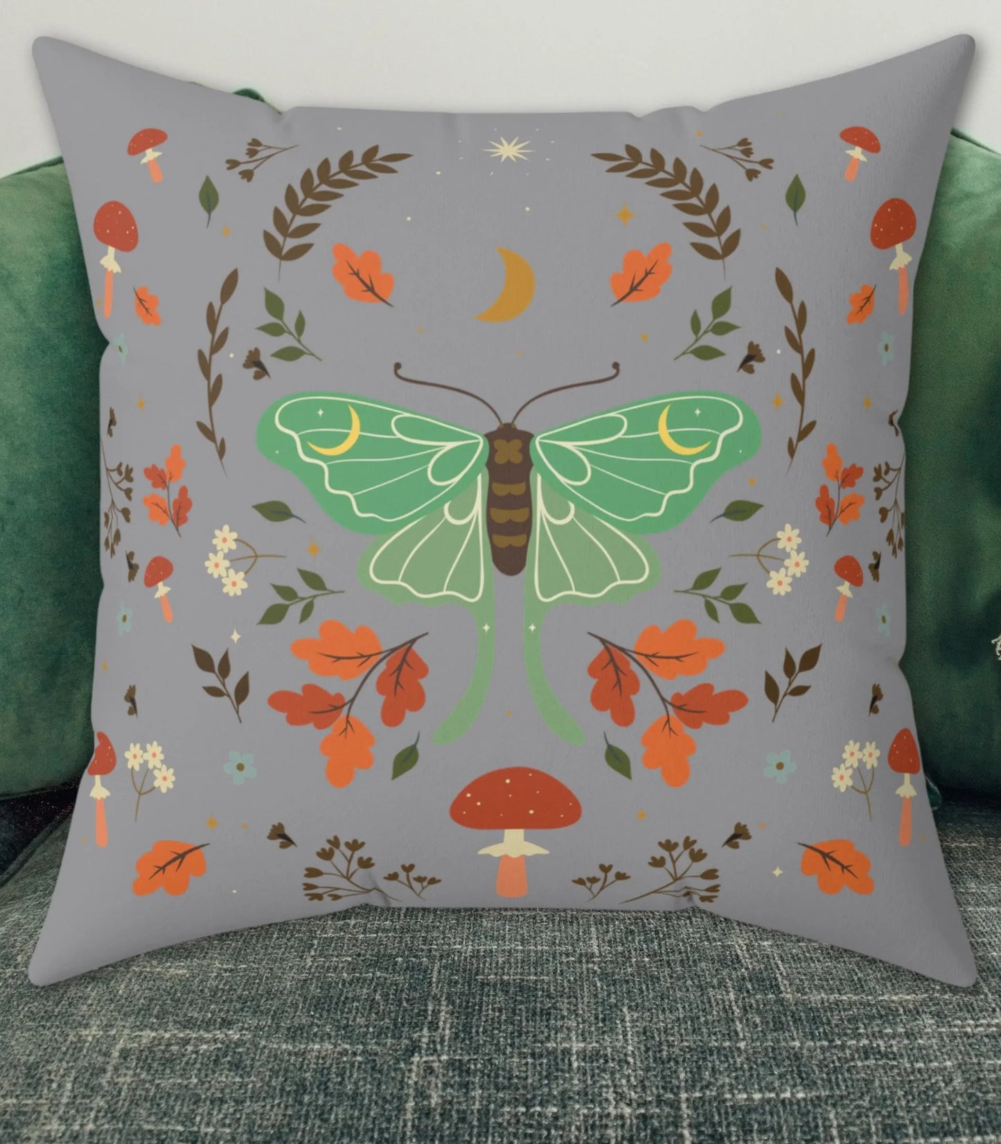 Decorative pillow with a green luna moth and autumn-themed design on a gray background