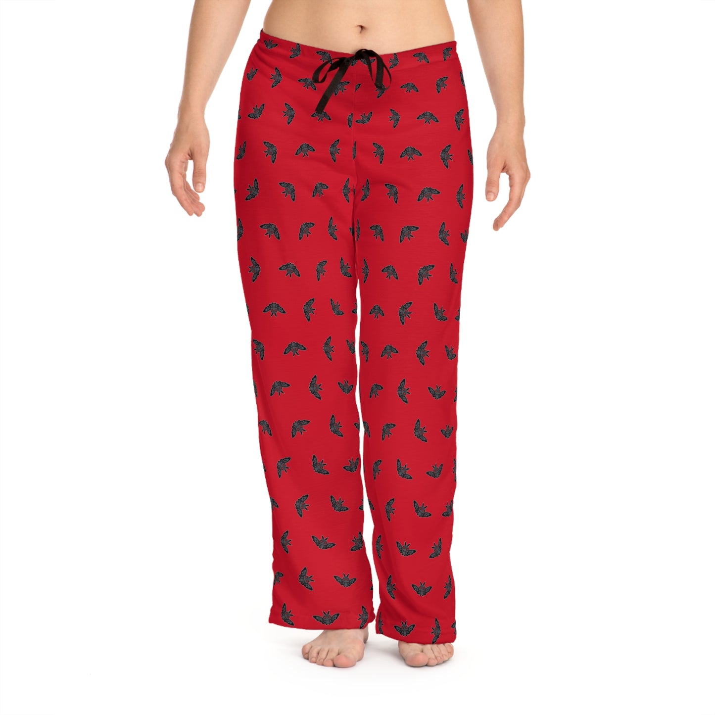 Red pajama pants with black pattern worn by a person on a white background