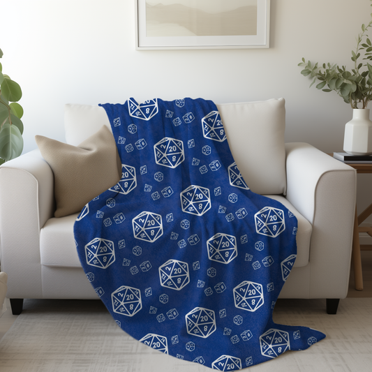 Blue blanket with white dice pattern draped over a white couch in a living room.