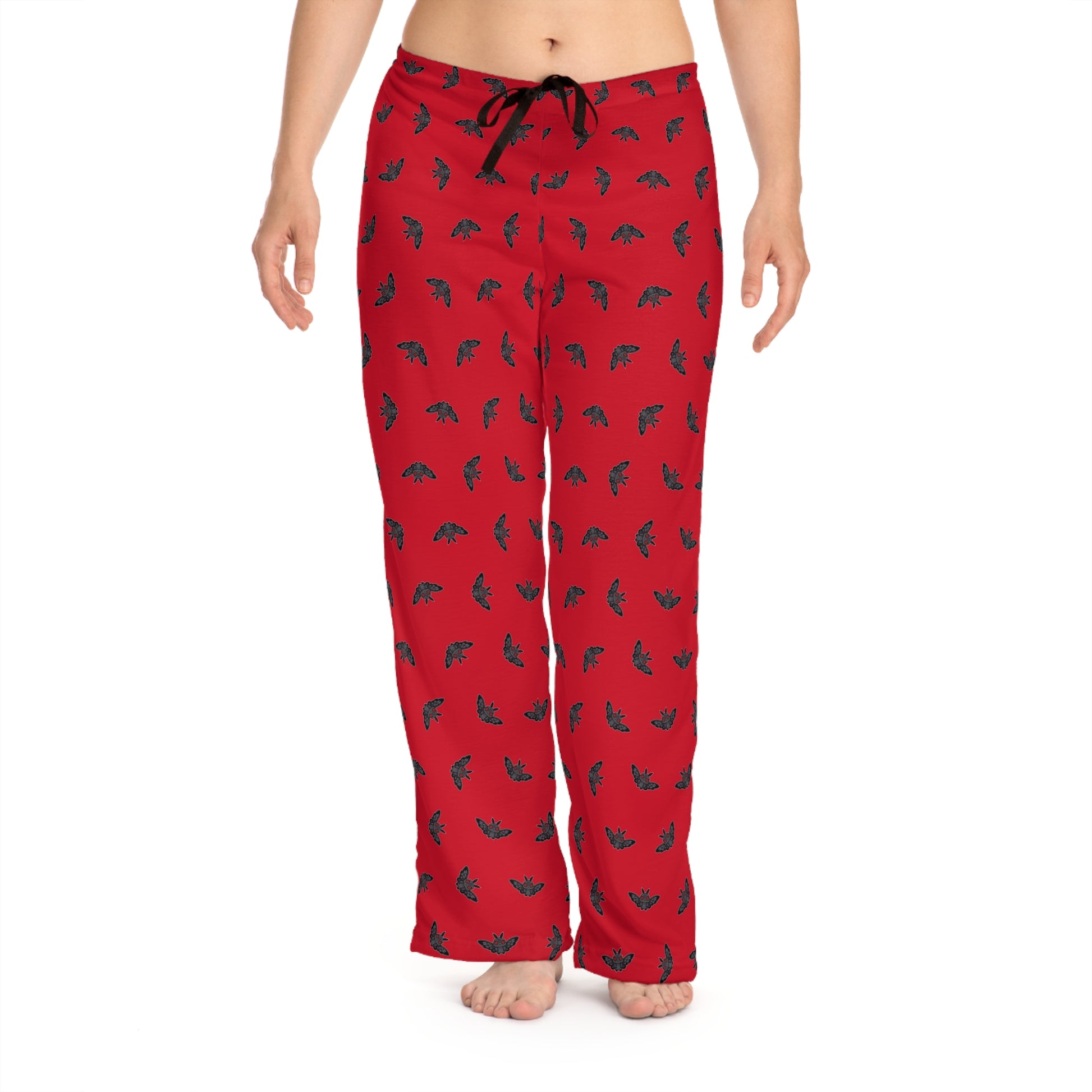 Red pajama pants with black pattern worn by a person on a white background